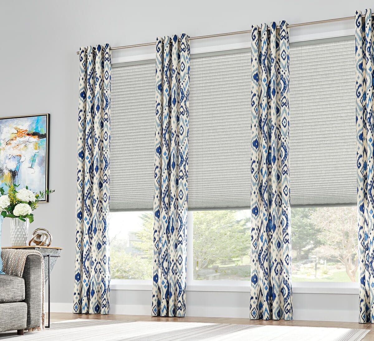 Contrast between solid-color cellular shades and patterned curtains