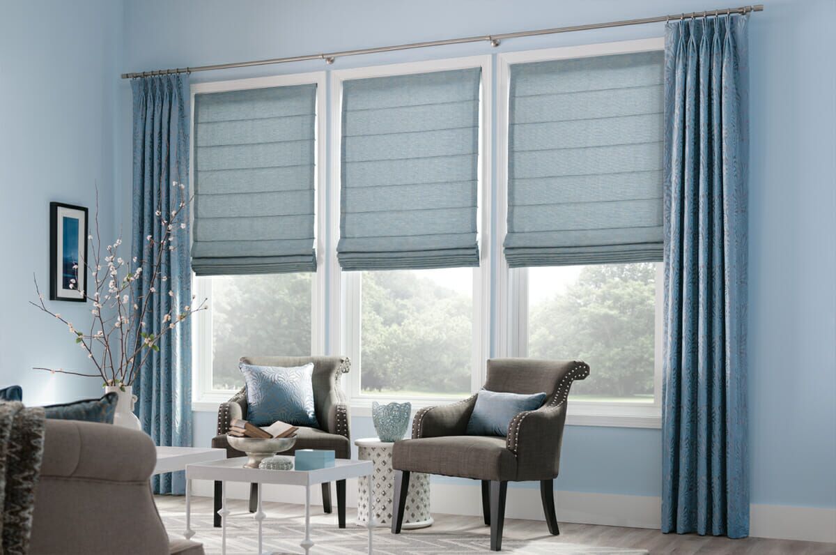 Classic flat Roman shades paired with patterned curtains