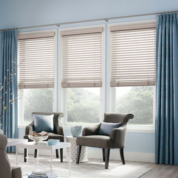 Curtains are layered over horizontal blinds
